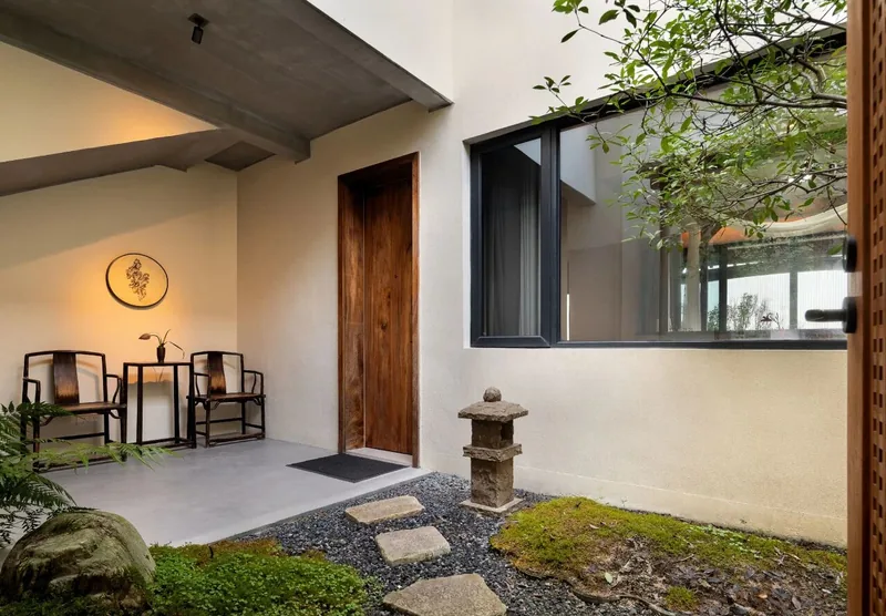 A guest-room courtyard with moss, stepping stones and white walls at Yinshi